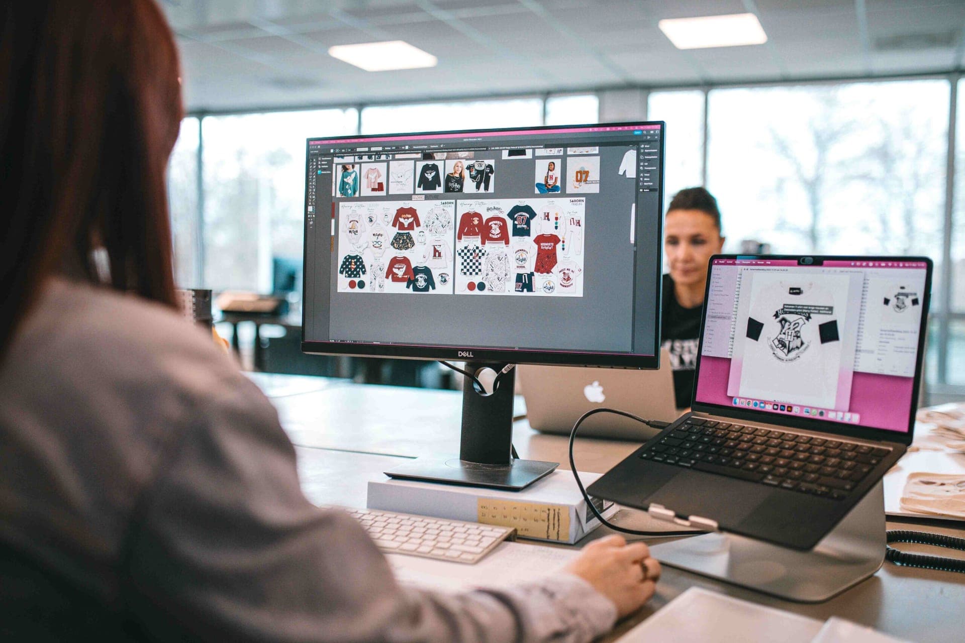 Ontwerper bekijkt ontwerpen van Harry Potter-kleding op een beeldscherm, met een Harry Potter-t-shirt op de laptop